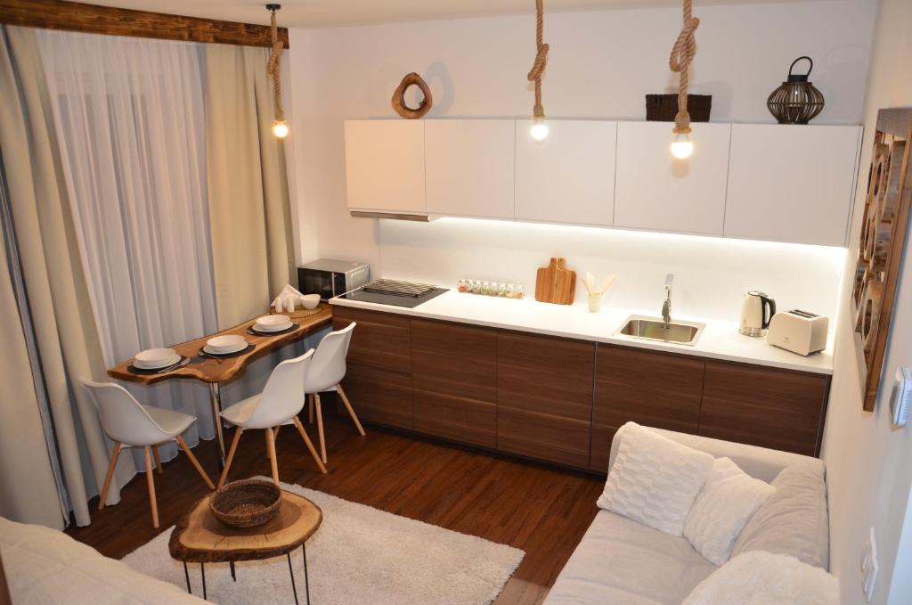 a kitchen and living room with a table and a couch at Primo Maxi in Smokovce
