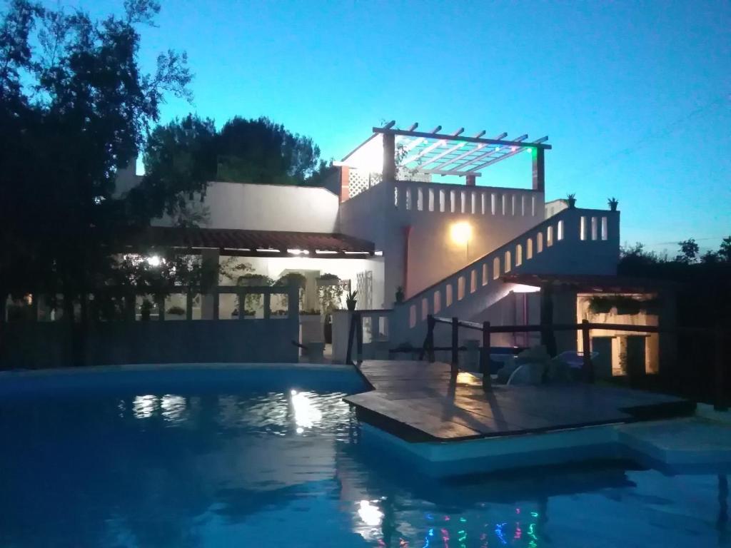 une maison avec une piscine la nuit dans l'établissement Masseria Lapica, à Oria