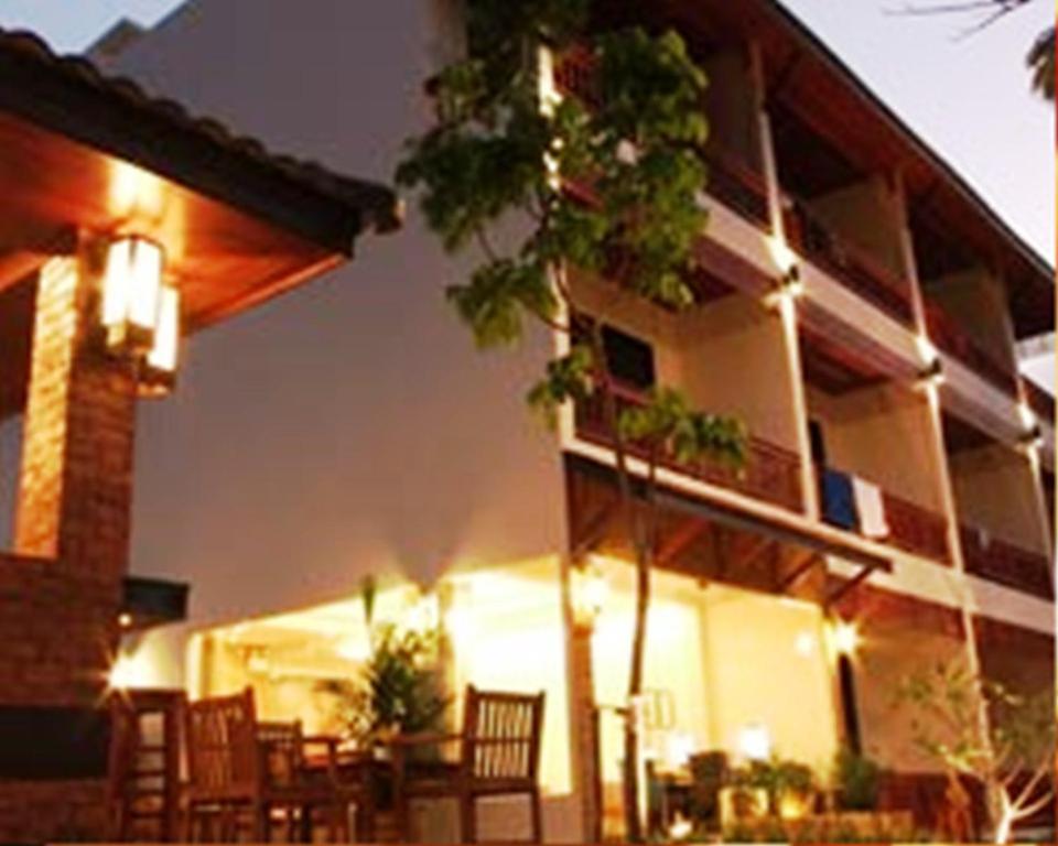 a building with chairs and a table in front of it at Katanoi Resort in Kata Beach