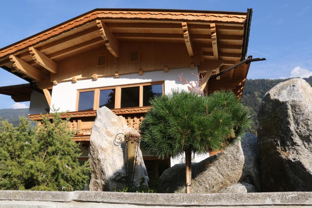 una casa en una roca con un árbol delante de ella en Das Enzian, en Aschau