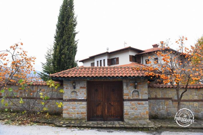 una casa con una puerta de madera en una pared de piedra en Villa Luxury Paradise Kastoria, en Lithiá