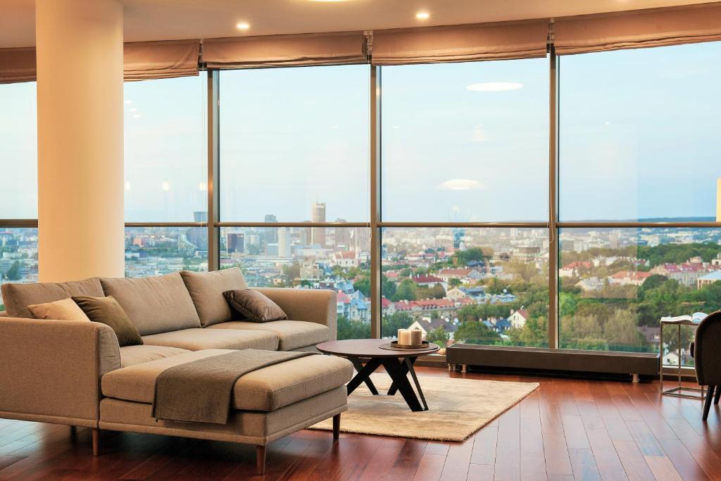 uma sala de estar com um sofá e janelas grandes em Luxury Panoramic Vilnius apartment em Vilnius