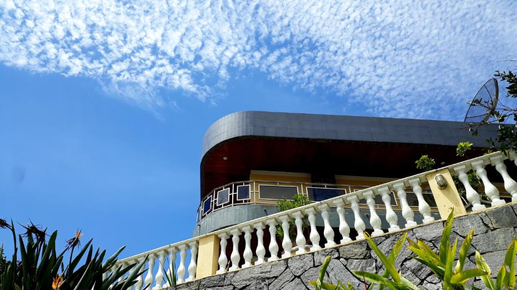 ein Gebäude mit einem Zaun davor in der Unterkunft Morada Recanto das Flores in Miguel Pereira