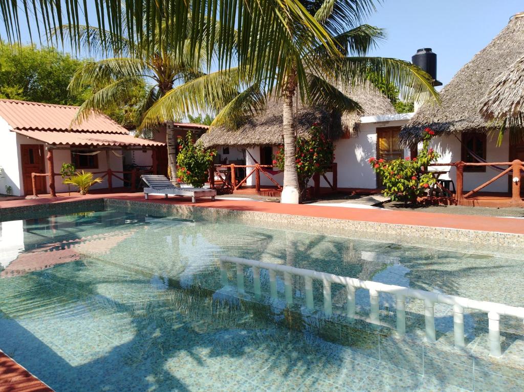 a swimming pool in front of a villa at Bungalows Familiares in Monterrico