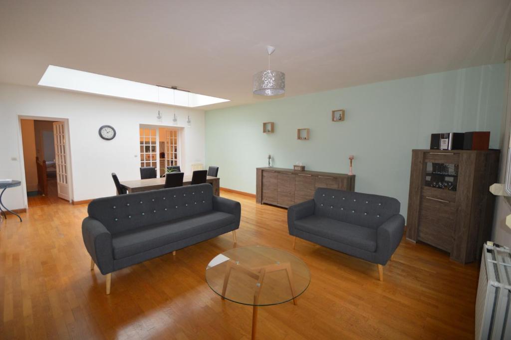 Sala de estar con 2 sofás y mesa en La Cotonnerie, en Saint-Quentin