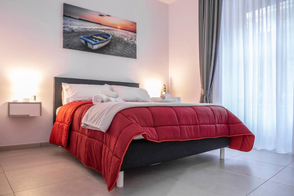 a bedroom with a bed with a red blanket at La Casina Rossa in Naples