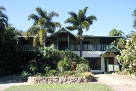 a large house with palm trees in front of it at True North B&B in Horseshoe Bay