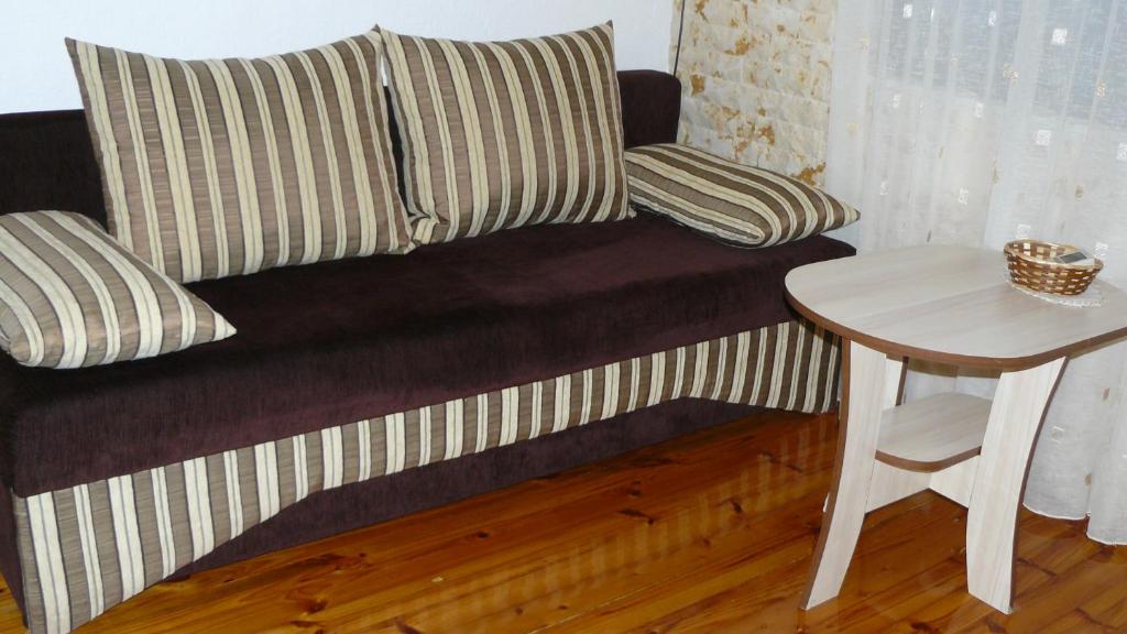 - un canapé avec des oreillers et une table dans la chambre dans l'établissement Geto Apartment, à Belogradchik