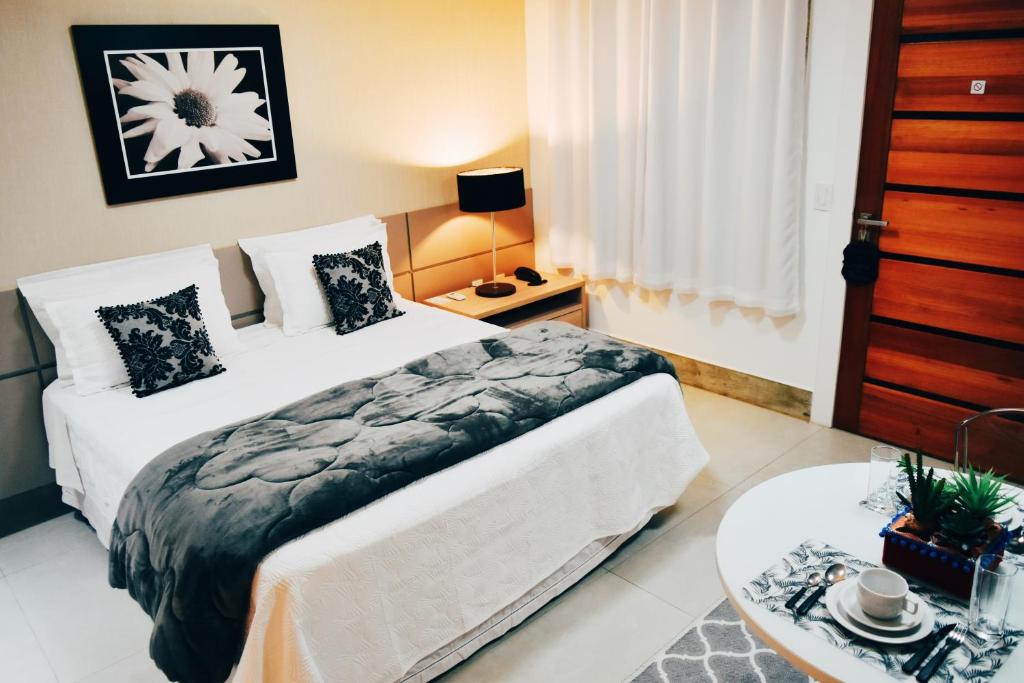 um quarto de hotel com duas camas e uma mesa em Flat's Refúgio Vip em Cabo Frio