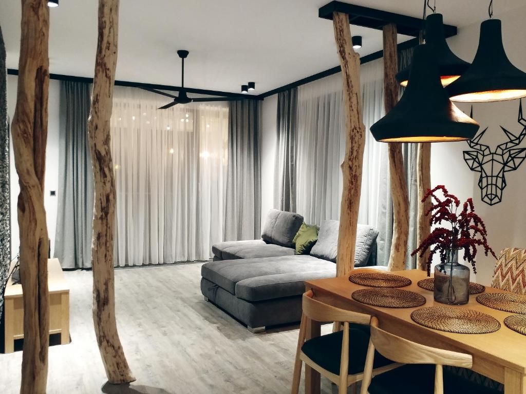 ein Wohnzimmer mit einem Sofa und einem Tisch in der Unterkunft DOR Apartment in Poiana Brașov