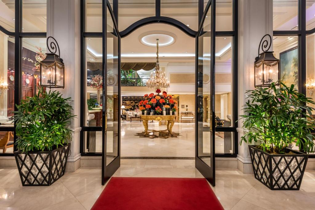 a lobby with two potted plants and a red rug at Beverly Hills Plaza Hotel & Spa in Los Angeles