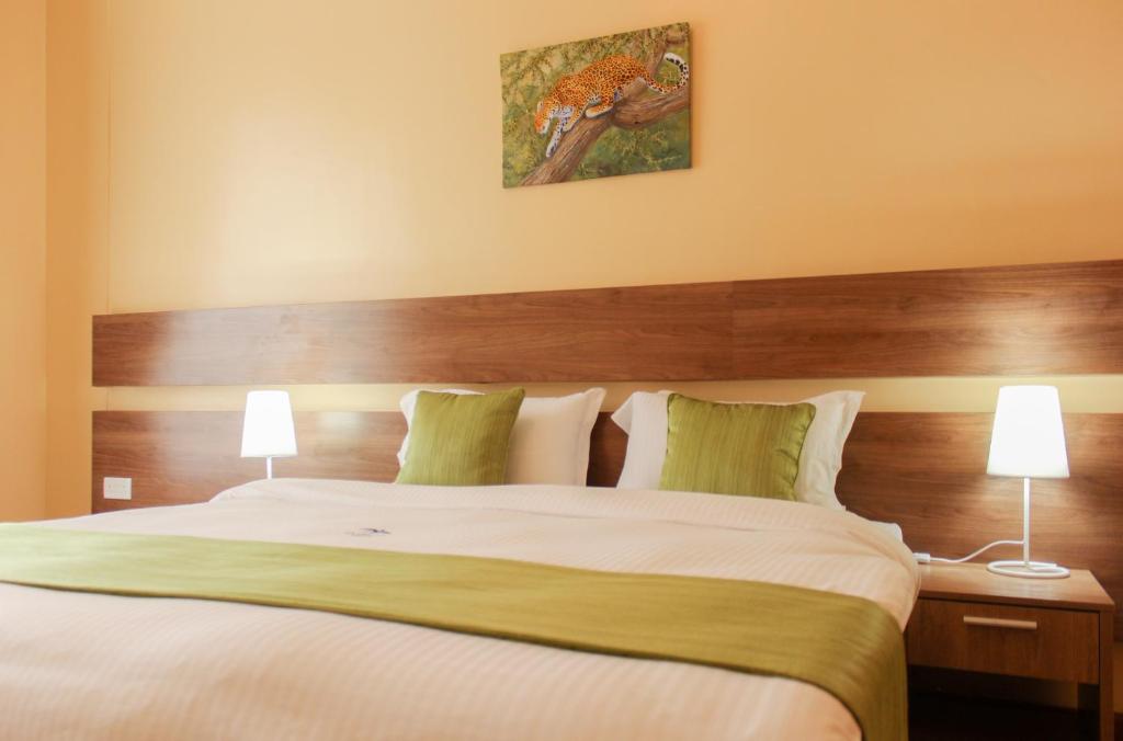 a bedroom with a large bed with two lamps at LIA Hotel & Training Centre in Nairobi