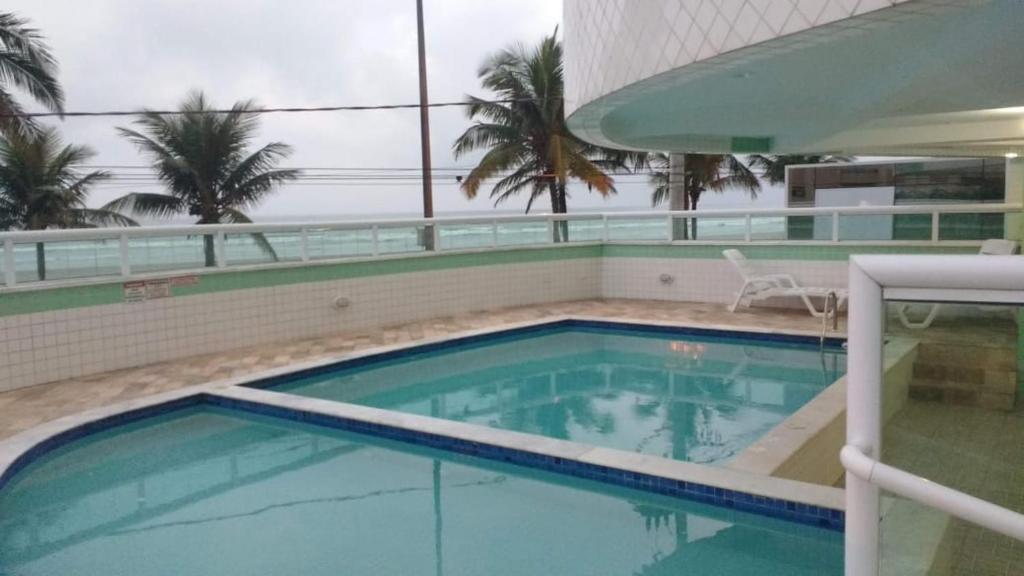 a large swimming pool in a building with palm trees at Residencial Bela Vista in Solemar