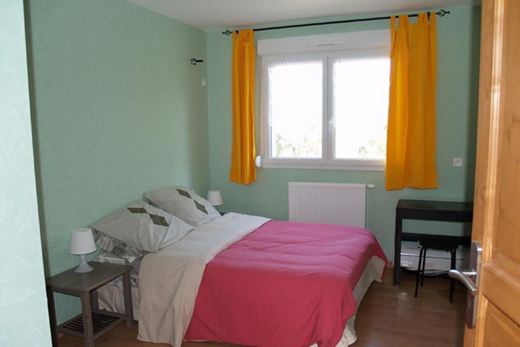 a bedroom with a bed and a window with orange curtains at Gîte des Mesanges in Haybes