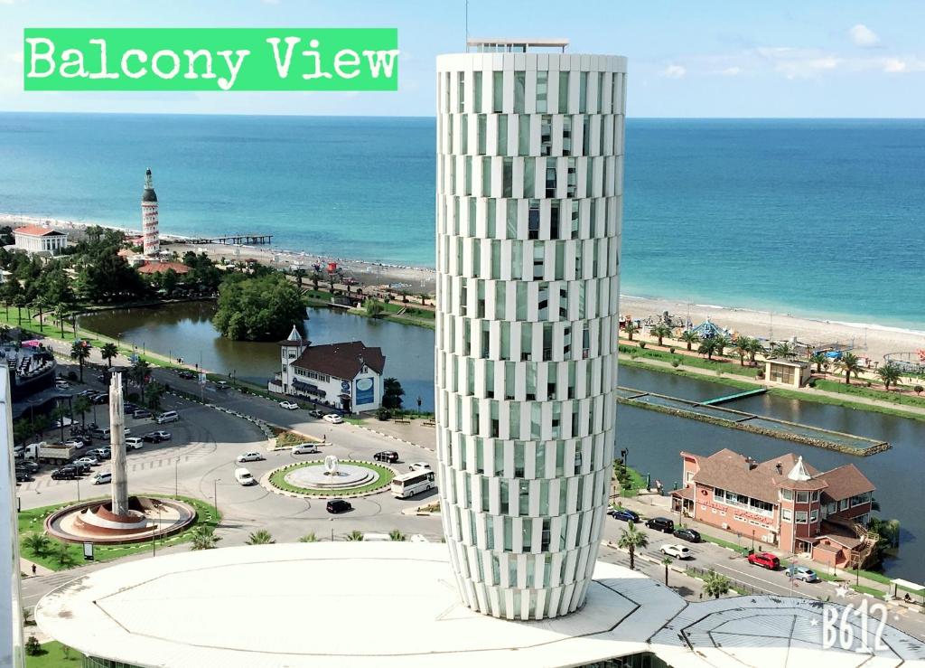 a tall white tower next to the ocean at Panorama Sea View Studio! in Batumi