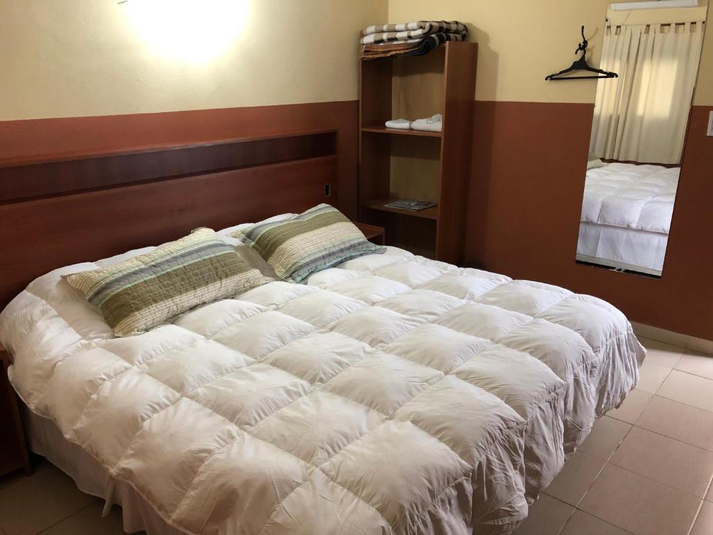 uma grande cama branca num quarto com um espelho em Hospedaje San Lorenzo em Corrientes