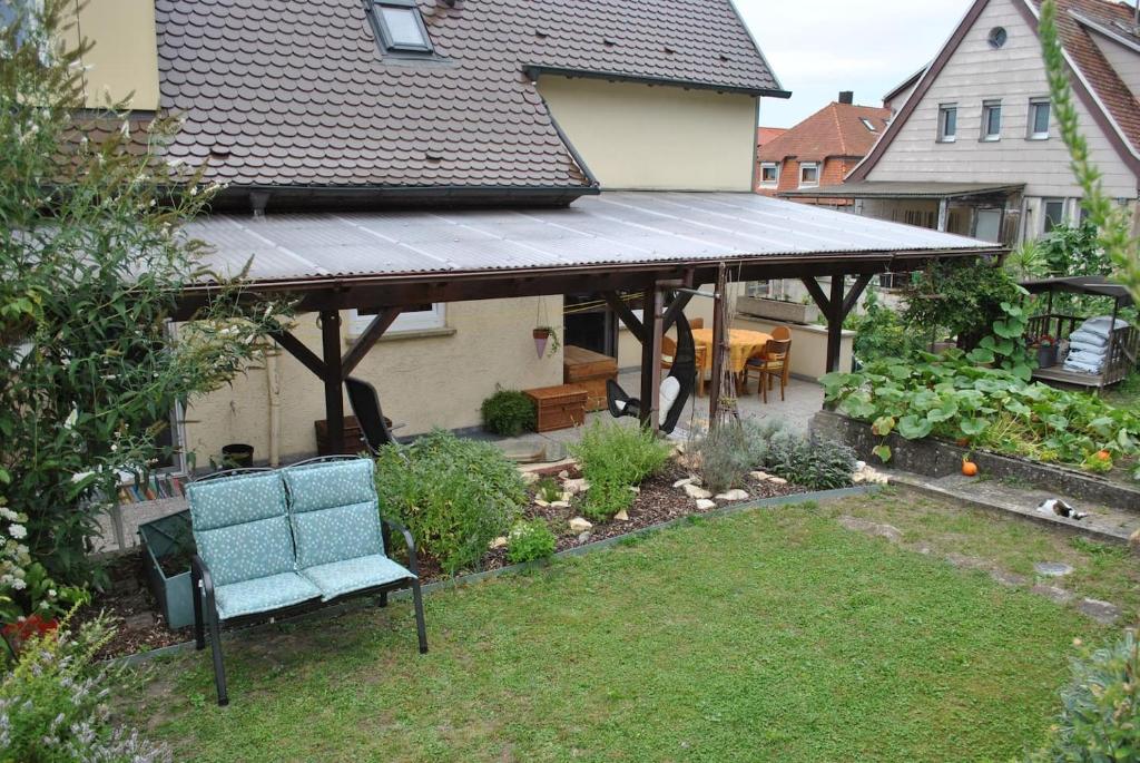 un pavillon avec une chaise bleue dans un jardin dans l'établissement Ferienwohnung Giessl, à Giengen an der Brenz