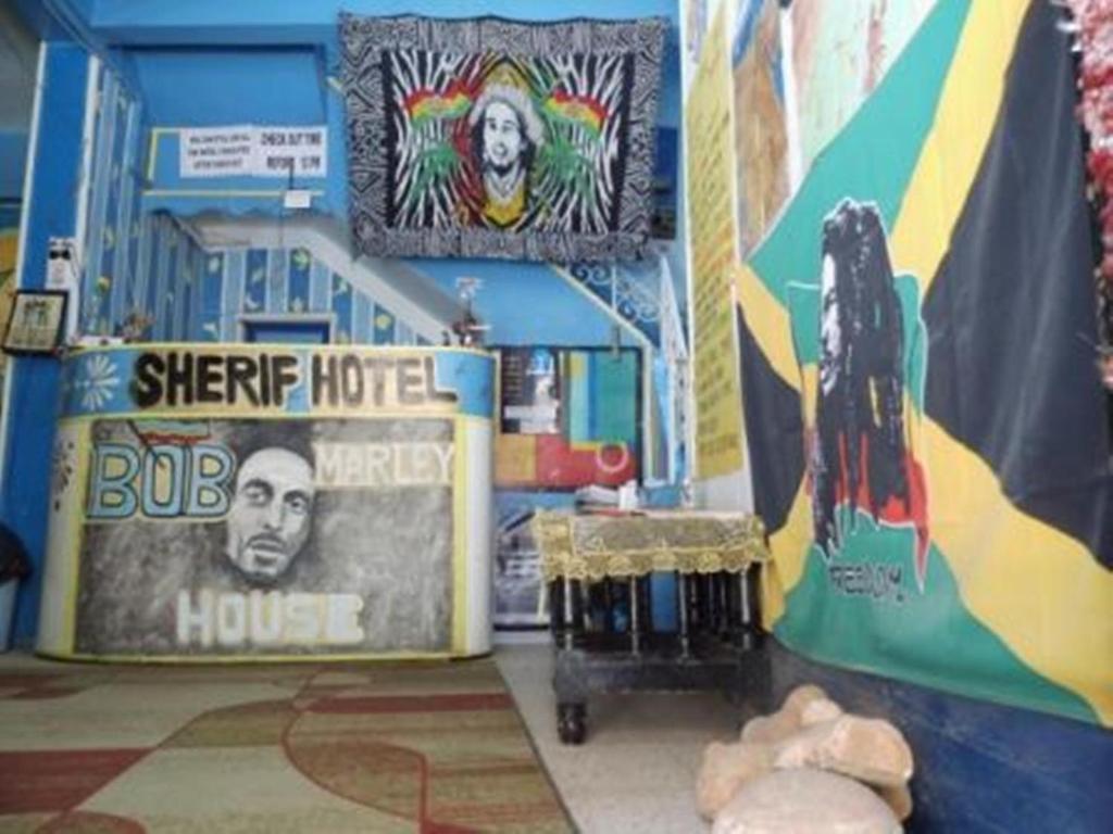 une chambre avec une grande maison avec un hôtel de surf et un panneau dans l'établissement Bob Marley House Sherief Hotel Luxor, à Louxor
