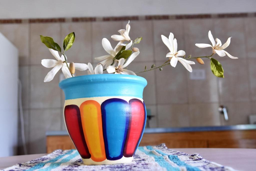 a colorful vase with white flowers in it on a table at El Indalo in Embalse