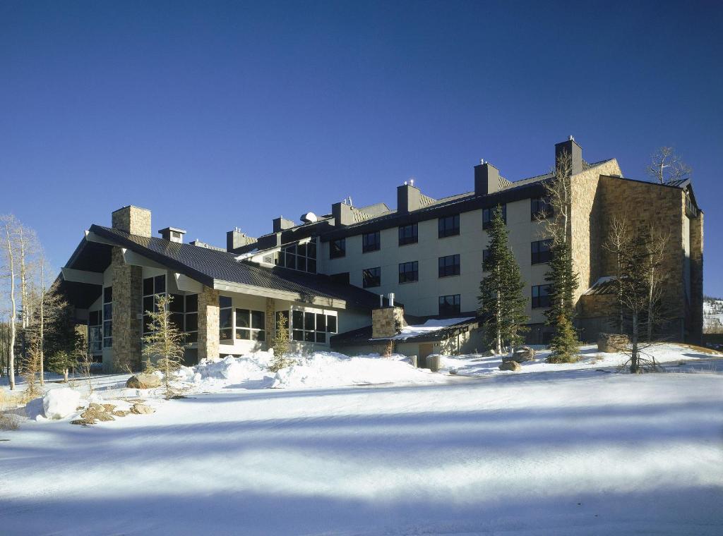 a large building with snow in front of it at Cedar Breaks Lodge in Brian Head
