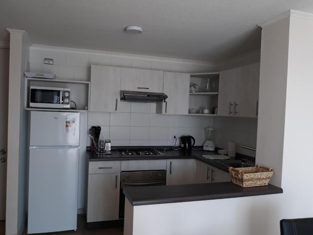 eine Küche mit weißen Geräten und einem weißen Kühlschrank in der Unterkunft Departamento en edificio Marazul in Coquimbo