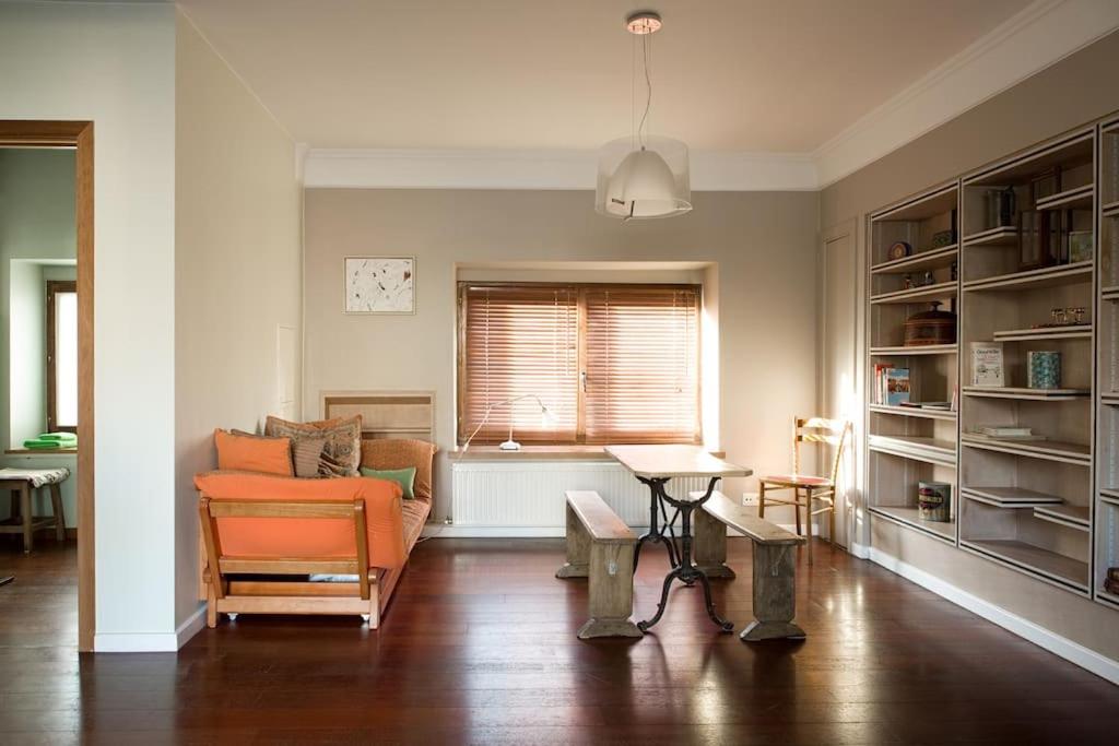 ein Wohnzimmer mit einem orangenen Sofa und einem Tisch in der Unterkunft B&B La Chambre de Plume in Brüssel