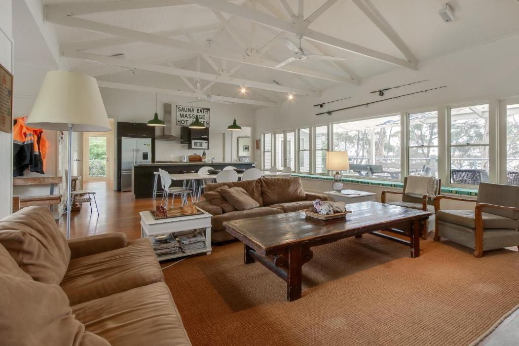 a living room with a couch and a table at Los Gatos - Metung Lakeside Retreat in Metung