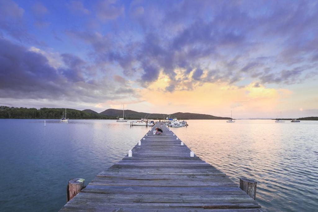 a dock on a lake with boats in the water at BIG4 Karuah Jetty Holiday Park in Karuah