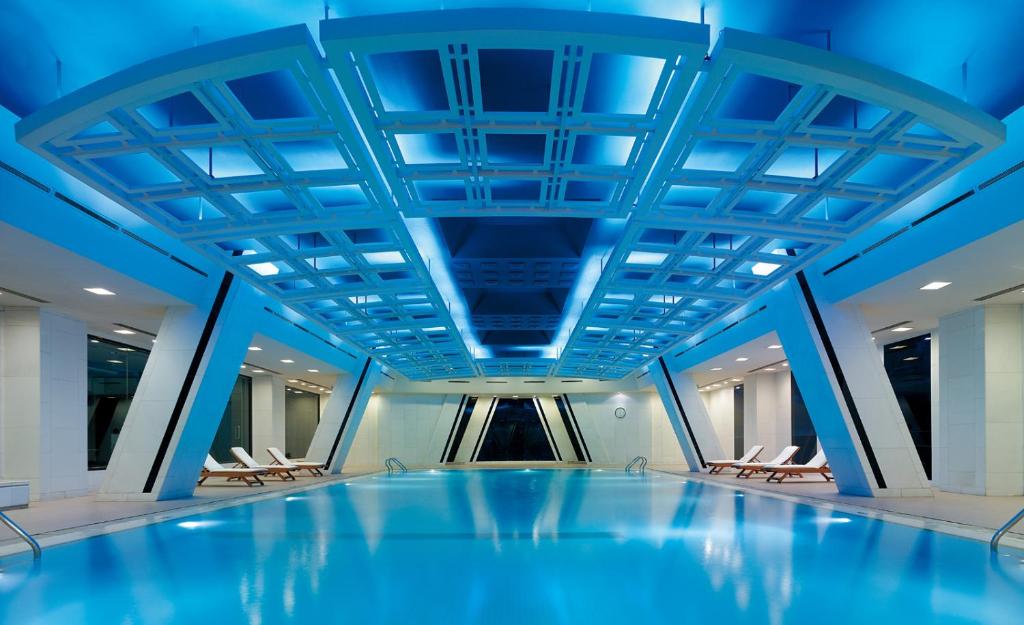 una piscina en un edificio con techos azules en China World Hotel, Beijing, en Beijing