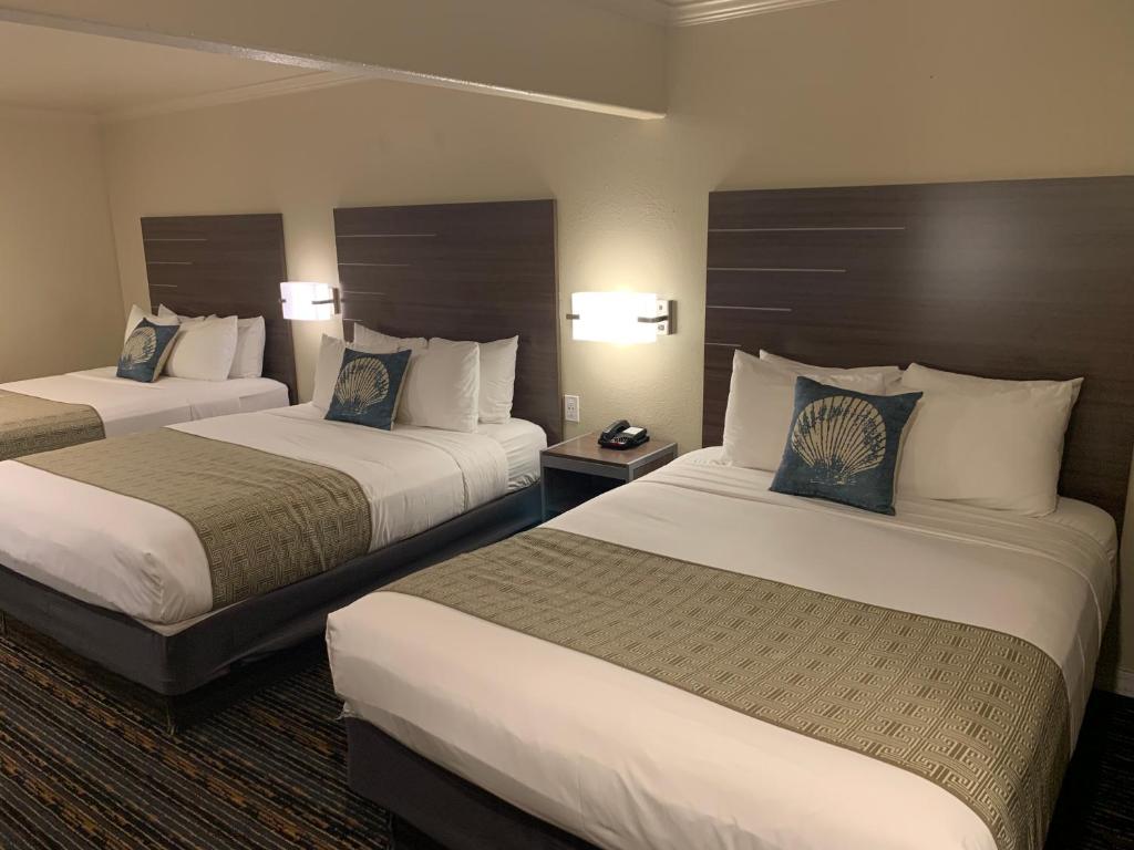 a hotel room with two beds and two lamps at El Castell Motel in Monterey