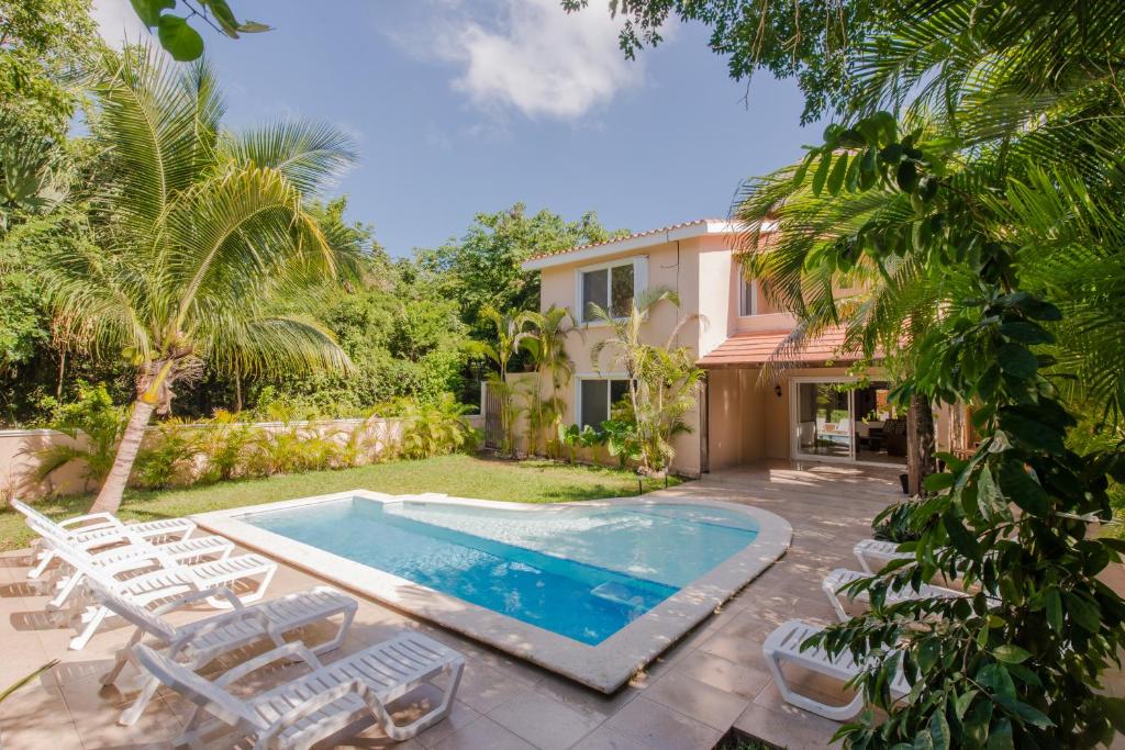 a villa with a swimming pool in a yard at Villas Picalu Studios & Suites in Puerto Aventuras