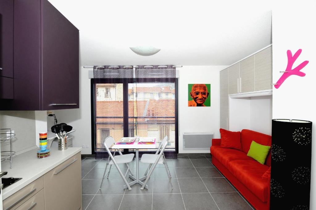 a living room with a red couch and a table at Le Campus Appartement in Nice