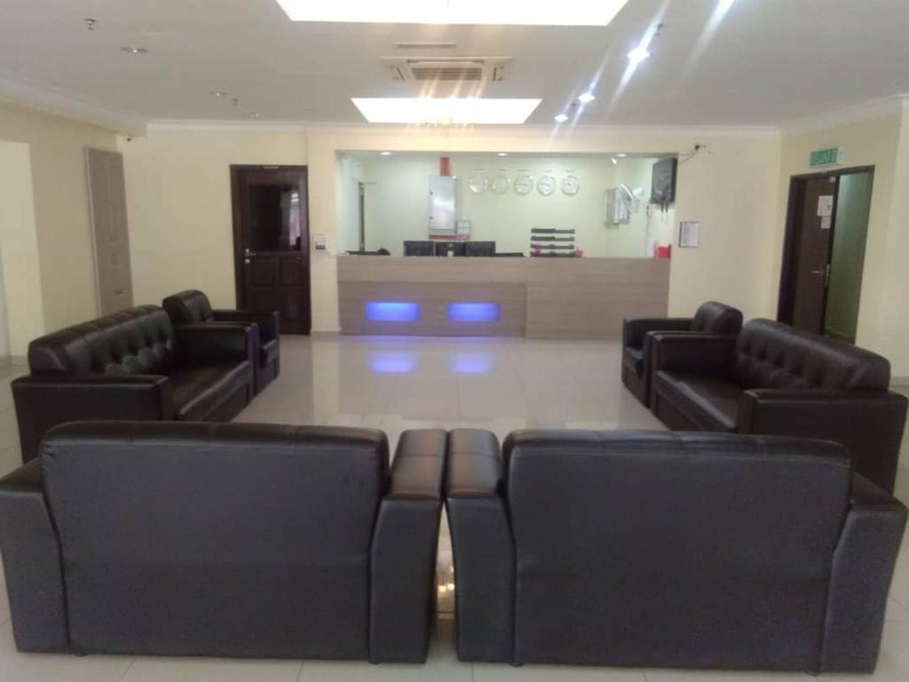 a waiting room with black chairs in a waiting room at Hotel Mewah Impiana in Kota Bharu