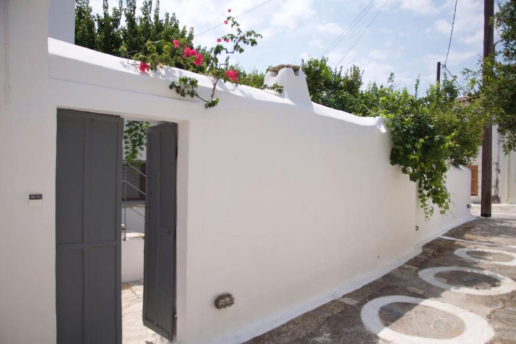 a white house with a black door and flowers at Village House in Hora-Pythagorio, Samos Island in Chóra