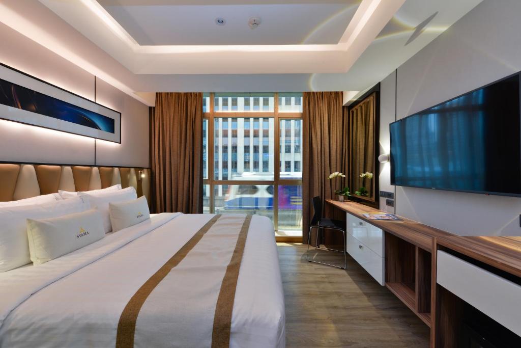 Syama Nana في بانكوك: غرفة فندقية بسرير كبير وتلفزيون بشاشة مسطحة