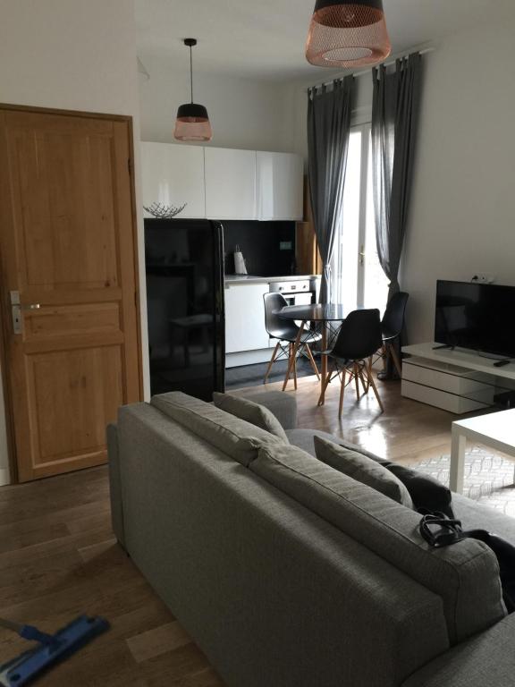 un salon avec un canapé et une cuisine dans l'établissement Charmant appartement hyper centre Comédie, à Montpellier