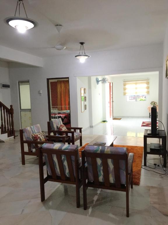 a living room with several chairs and a table at RB Double Storey Bandar Tasik Selatan Homestay in Kuala Lumpur