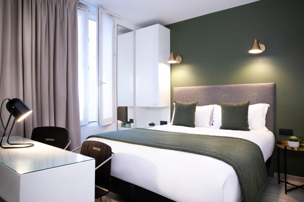 une chambre avec un grand lit blanc et une fenêtre dans l'établissement Hotel Brady - Gare de l'Est, à Paris