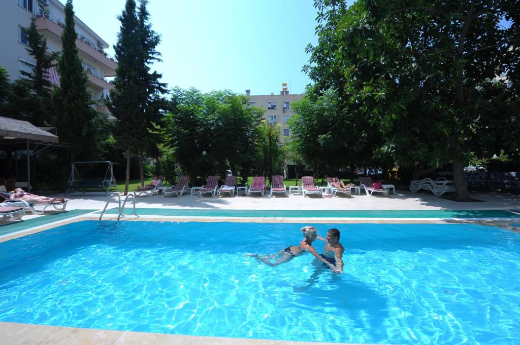 a man and a woman sitting in a swimming pool at Suite Laguna Otel in Antalya