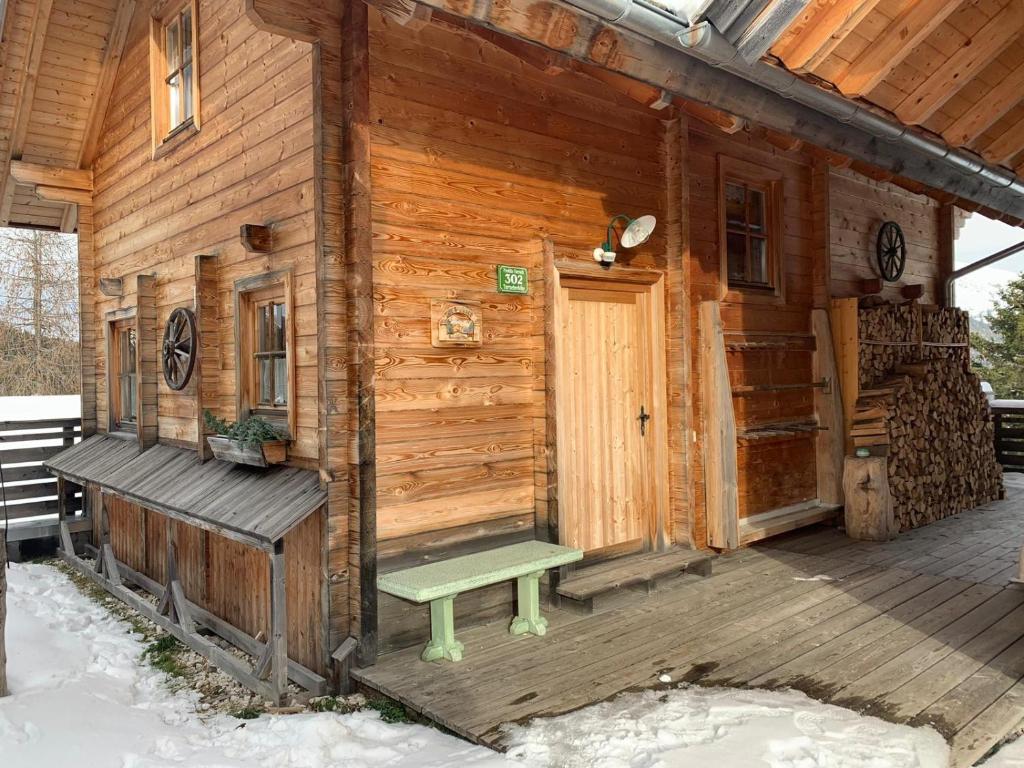 トゥルラッハー・ヘーエにあるChalet Nr. 302の木造キャビン(ベランダにベンチ付)