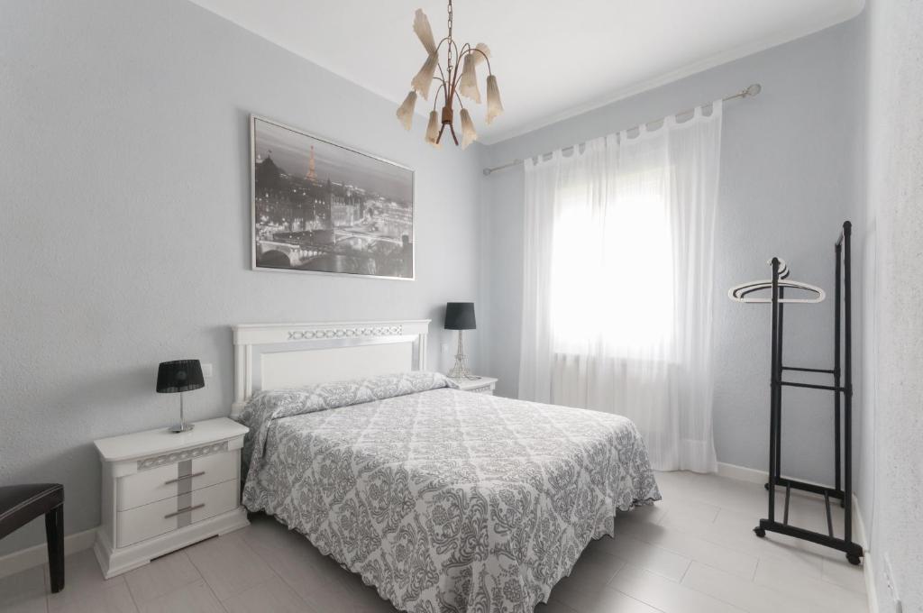 マドリードにあるApartamento 6 Mirasierrasの白いベッドルーム(ベッド1台、窓付)