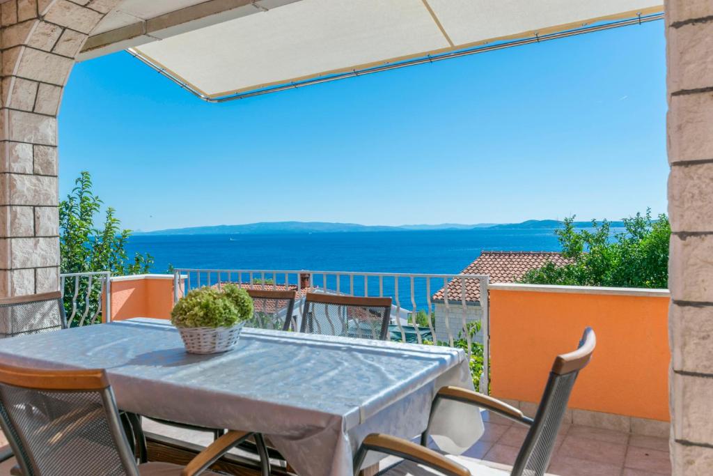 d'une table et de chaises sur un balcon avec vue sur l'océan. dans l'établissement Apartments Babaja, à Trogir