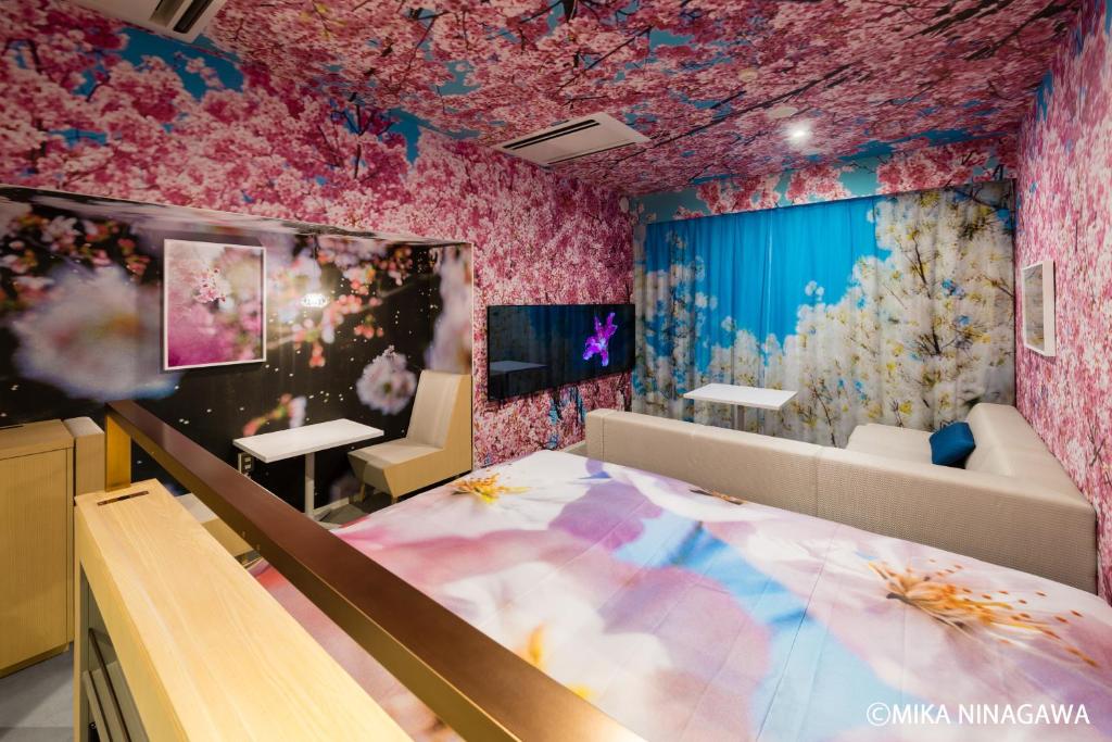 京都市にあるホテル　アンテルーム　京都のピンクの花の壁紙を用いたベッドルーム1室