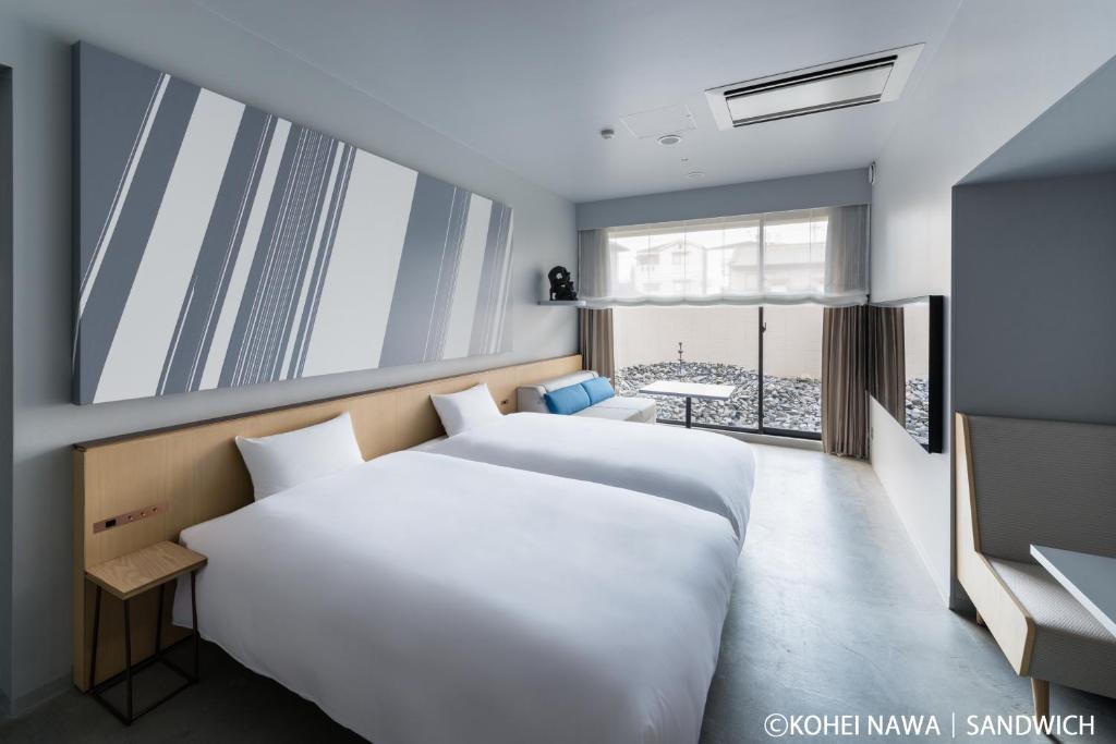 京都市にあるホテル　アンテルーム　京都のベッドが2つと窓があるホテルの部屋