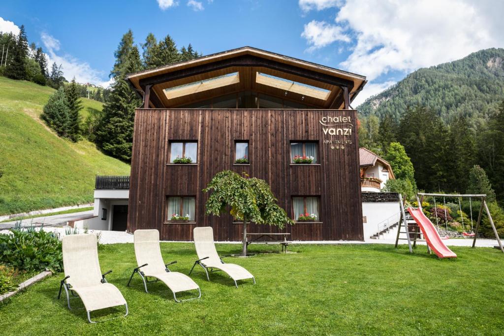 um grupo de cadeiras em frente a um edifício em Chalet Vanzi em San Martino in Badia