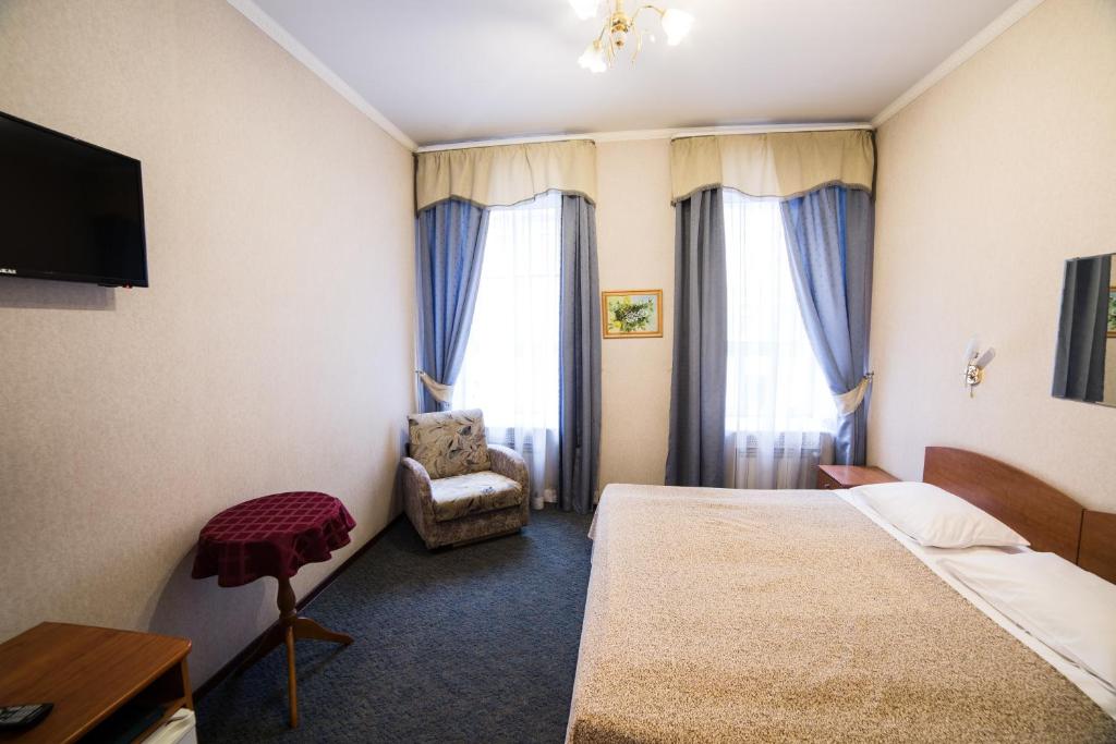 Habitación de hotel con cama y silla en Амулет на Большом, en San Petersburgo