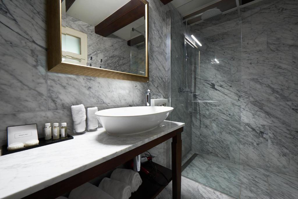 a bathroom with a white sink and a shower at Château Gütsch in Luzern