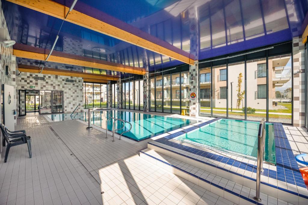 an indoor swimming pool in a building with a building at Apartamenty Sun & Snow Pięć Mórz z basenem in Sianozety