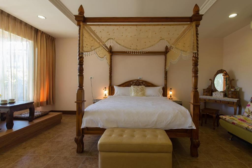 a bedroom with a four poster bed and a chair at Gengmengyuan B&amp;B in Xikou