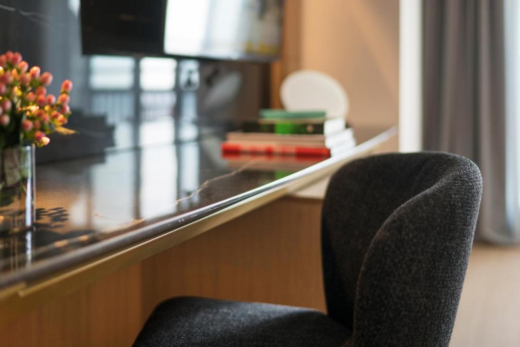 a chair sitting in front of a glass table with a mirror at Hotel Excelsior in Dubrovnik